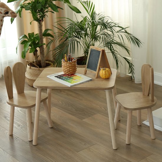 Houten kindertafel met twee stoeltjes met konijnenoren, een mand met potloden en een bord.