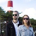 Man en vrouw met zonnebril bij een vuurtoren.