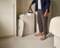 Man met ecru wasmand, twee compartimenten, in een slaapkamer.