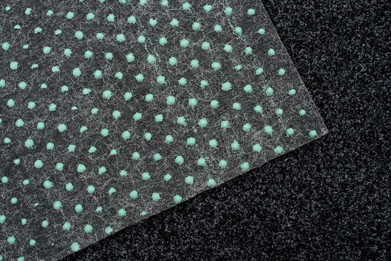 Dessous d'un tapis gris foncé avec un motif antidérapant vert à pois