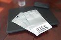 Drie zilverkleurige zakjes met LUQ PRODUCTS logo op een laptop.