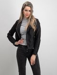 Model in zwarte bikerjack, gestreepte top en grijze jeans met knopen.