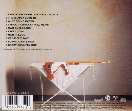 Achterkant van de "Money and Cigarettes" albumhoes met nummers en een gitaar op een tafel.