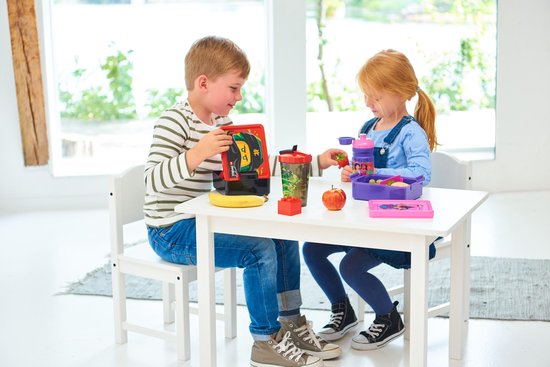 Un garçon et une fille sont assis à une table avec des produits de déjeuner LEGO Friends. La fille a une gourde violette.