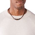 Bruine leren ketting met houten en metalen kralen, gedragen door een man in een beige trui.