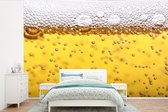 Behang - Fotobehang Bierbubbels in glas met bier - Breedte 390 cm x hoogte 260 cm