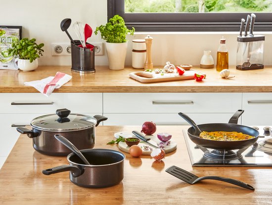 Keuken met diverse Tefal kookgerei. Een zwarte koekenpan met een omelet erop staat op het fornuis.
