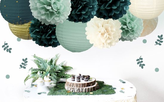 Een gedekte tafel met cupcakes, mini-muffins op een boomstam en decoraties van papier in groentinten.