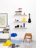 Witte kast met LEGO opbergdozen in blauw en wit, en speelgoed op planken.
