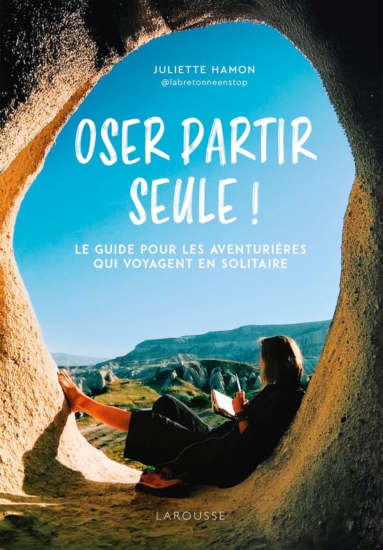 Couverture du livre 'Oser partir seule!' par Juliette Hamon. Une femme est assise dans une grotte, regardant vers l'extérieur. Texte: 'Oser partir seule! Le guide pour les aventurières qui voyagent en solitaire'.