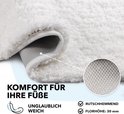 Gros plan du poil doux et haut d'un tapis de bain crème avec un envers antidérapant.