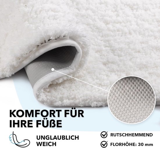 Gros plan du poil doux et haut d'un tapis de bain crème avec un envers antidérapant.