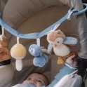 Baby speelt met kinderwagenhanger met vos, paddenstoel, bosbessen en uil.