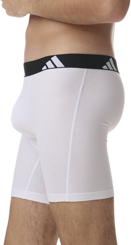 Zijkant van een witte Adidas boxer met zwarte tailleband met logo.