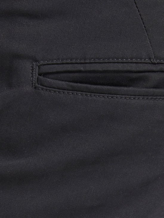 Detail van de steekzak van een zwarte chino broek.