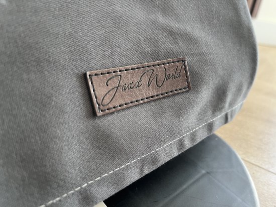 Detail van grijze stof met bruin "Jaxx World" label.
