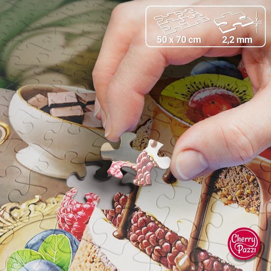 Hand legt een stukje van een 1000-delige puzzel van een fruitige chocoladetaart.