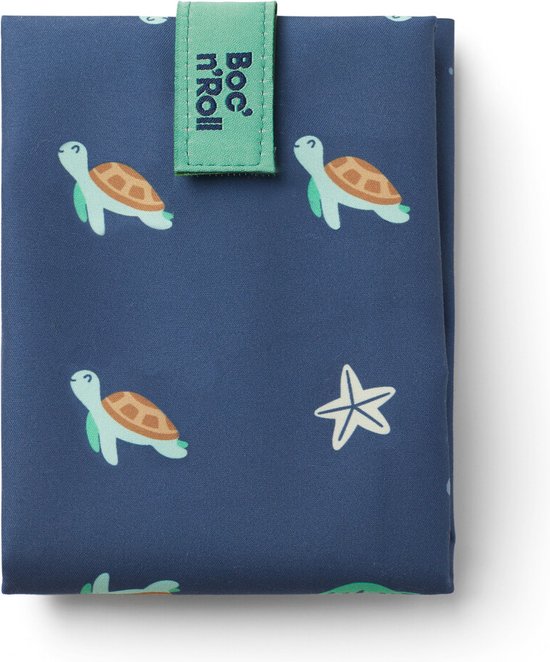 Donkerblauw Boc'n'Roll boterhamzakje gesloten met schildpad- en zeesterprint. Groene sluiting met logo.