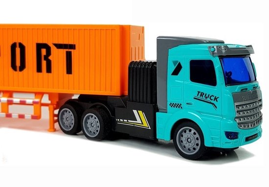 Close-up van de blauwe truck cabine en oranje trailer met "EXPORT", gedetailleerde wielen.