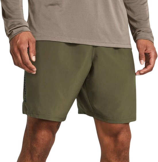 Man in legergroene shorts en grijze trui met halve rits