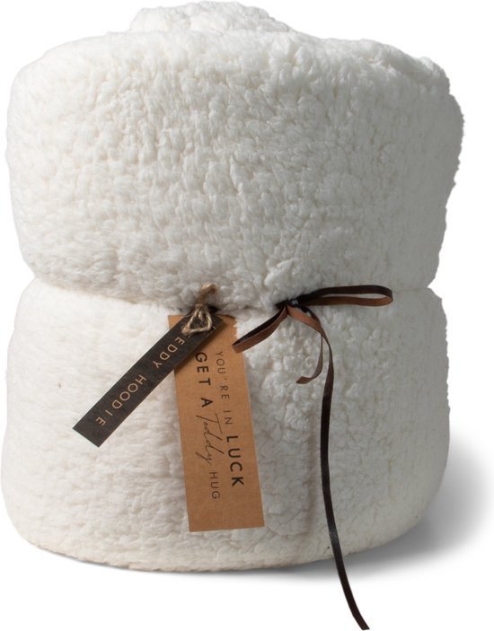 Een opgerolde witte teddy deken, vastgebonden met bruin lint en voorzien van twee labels: "GET A LUCKY BEAR HUG" en "YOU'RE IN".