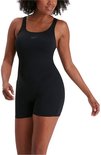 Model draagt zwart Speedo sportbadpak met pijpjes, half gedraaid.