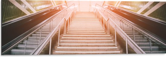 WallClassics - Dibond - Zonnestralen over Roltrap en Trap in Metrostation - 90x30 cm Foto op Aluminium (Met Ophangsysteem)