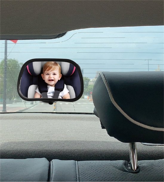 Baby in autostoel lach in de autospiegel, bevestigd aan de achterruit.