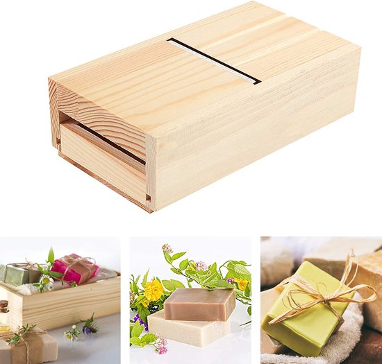 Houten zeepsnijder in een ladebox met vers gesneden zeepjes omringd door bloemen.