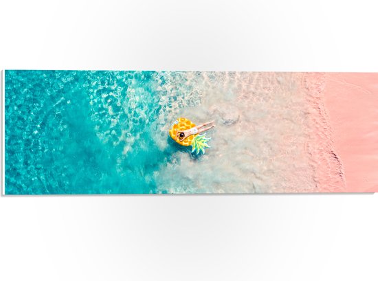 PVC Schuimplaat - Bovenaanzicht van Vrouw Liggend op Floatie in Heldere Oceaan - 60x20 cm Foto op PVC Schuimplaat (Met Ophangsysteem)