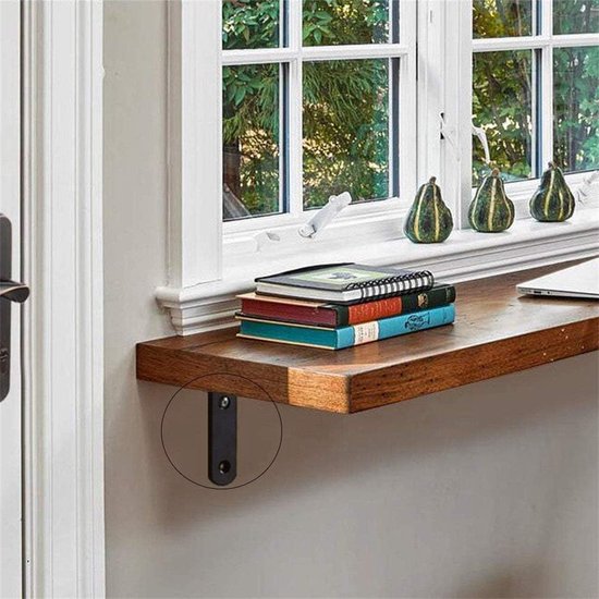 Een zwarte hoekbeugel ondersteunt een houten plank met boeken en een laptop bij een raam.