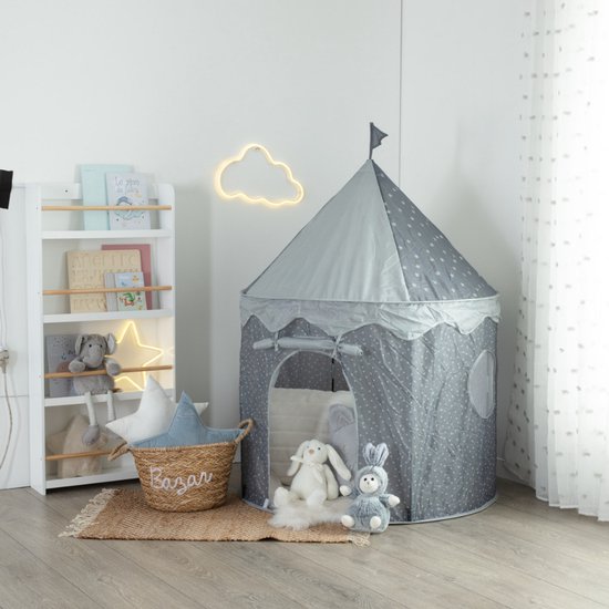 Grijze prinsessentent met witte sterrenprint, open instap, raampjes en een vlaggetje bovenop. Boekenkast met knuffels ernaast.