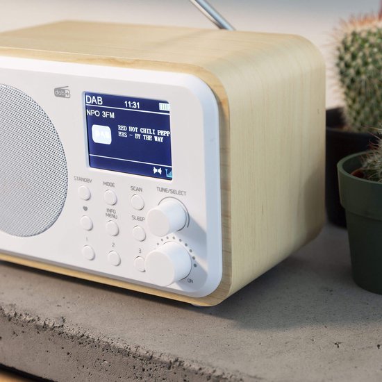 DAB radio met wit front en houten kast, toont 'NPO 3FM' en 'Red Hot Chili Peppers'.
