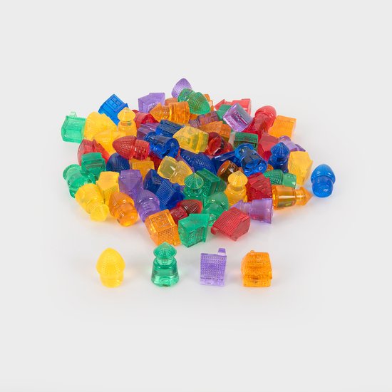 Une grande pile de petites maisons et bâtiments transparents multicolores sur fond blanc.