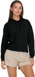 Model draagt een zwarte cropped hoodie en beige shorts.