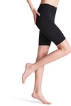 Zwarte, knielange shapewear met subtiel geweven patroon, gedragen met pumps.