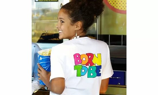 Mannequin portant un t-shirt blanc avec "BORN TO BE" en lettres multicolores.