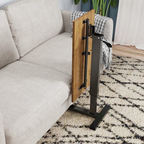 Gevouwen houten laptoptafel naast een grijze bank.