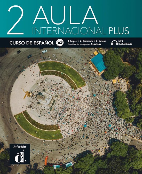 Boek "Aula Internacional Plus 2", cursus Spaans A2, met een afbeelding van een vogelvlucht over een plein vol mensen en een monument.
