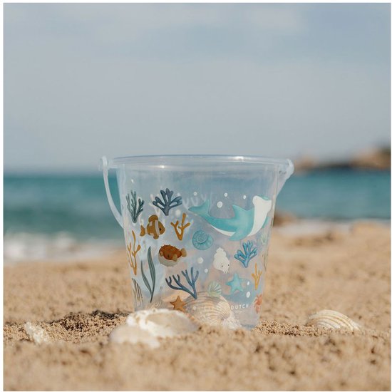 Lichtblauwe emmer met zeelevenprint op het strand.
