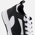 Close-up van de zijkant van een zwart-witte sneaker met witte veters en stiksels.
