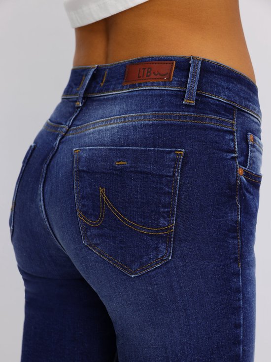 Close-up van de achterkant van een donkerblauwe jeans met opgestikte zakken met oranje stiksels.