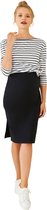 Model draagt een zwarte zwangerschapsrok in kokermodel met split en een gestreepte top met knoop aan de zijkant.