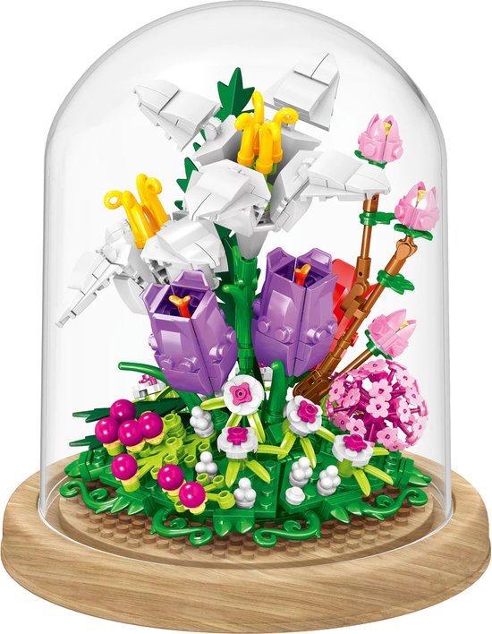 Bouwstenen bloemenarrangement van witte lelies en paarse tulpen onder een glazen stolp.