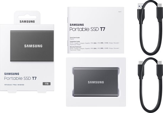 Verpakking van een grijze Samsung Portable SSD T7 met accessoires en handleiding.