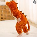 Zijaanzicht van een jong kind in bruine dinosaurus onesie.