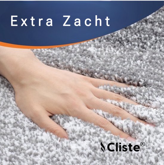 Hand die door de zachte, pluizige textuur van een grijze badmat gaat. Extra zacht.