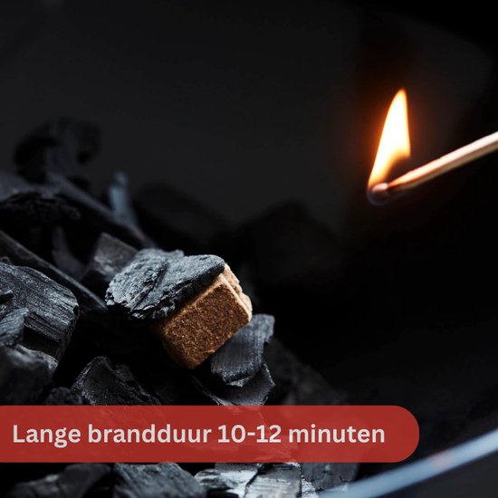 Een aanmaakblokje wordt aangestoken met een lucifer te midden van zwarte houtskool. Tekst: 'Lange brandduur 10-12 minuten'.