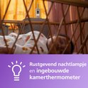 Babyfoon op een nachtkastje bij een wiegje, met tekst: 'Rustgevend nachtlampje en ingebouwde kamerthermometer'.