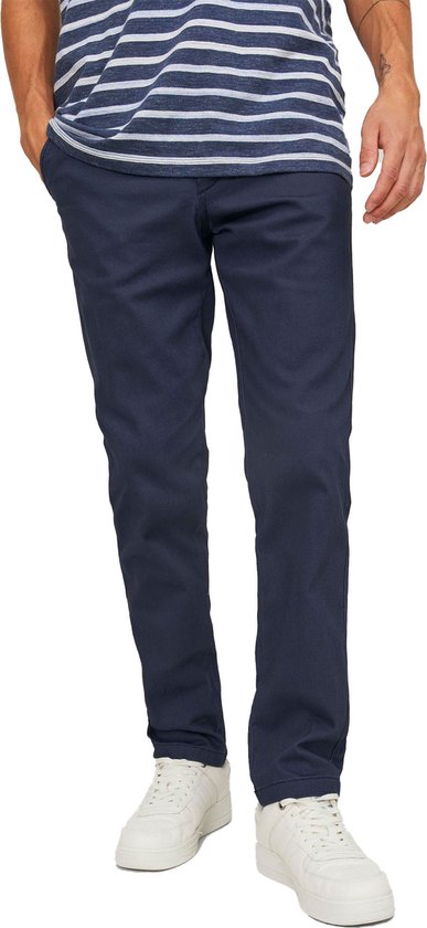 Onderlichaam van een man met gestreept blauw-wit T-shirt en donkerblauwe chino broek.